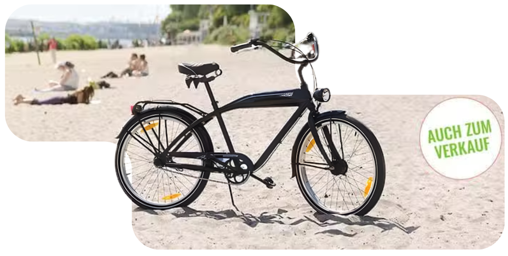 Black bicycle on the beach with 'Auch zum Verkauf' text in green circle.