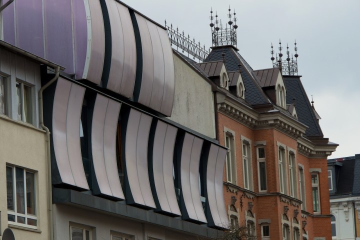 Modern and traditional architecture with striped awnings and ornate rooftops.