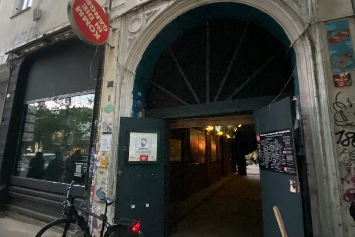 Entrance to an old building passage with a bicycle nearby.